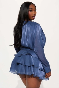 Detail showing the shiny tiered ruffle hem and metallic texture of the navy mini dress