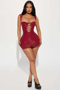 Détail de robe rouge avec découpes, anneaux métalliques et laçages croisés sexy