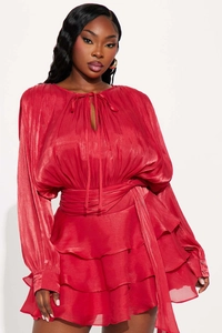 Close-up of dark red ruffled mini dress featuring pleated texture and tie-neck detail