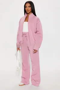 Detail of light pink tracksuit set featuring a stand collar zip-up and drawstring wide-leg pants