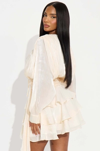Detailed close-up of champagne tiered mini dress with metallic pleated fabric and lace-up design