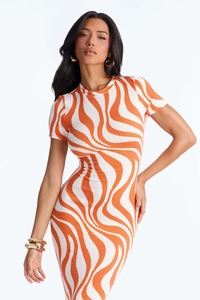 Nahaufnahme der Rippstrick-Textur am figurbetonten Kleid mit orange-weißem Wellenprint
