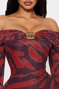 Détail d'une robe à épaules dénudées avec motif flamme violette et décor doré