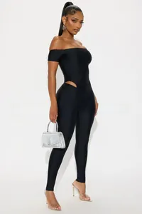 Detail view of black off-shoulder jumpsuit with waist cut-outs and sleek elastic fabric