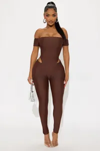 Detailed close-up of dark brown off-shoulder jumpsuit featuring symmetrical waist cut-outs