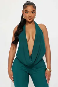 Detail of dark teal halter neck jumpsuit showing draped neckline and open back design