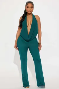 Front view of deep V-neck halter jumpsuit in dark green textured fabric with wide legs