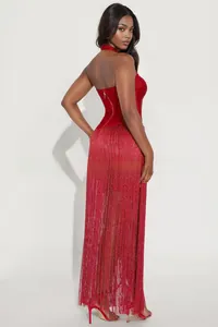 Detailed back view of red halter dress featuring a gold zipper and long fringe tassels