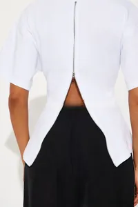 Vue détaillée du dos d'un t-shirt blanc orné d'une fermeture éclair en métal argenté