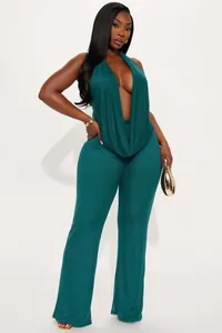 Detail of teal halter neck jumpsuit showing deep V-neckline and wide leg trouser fit