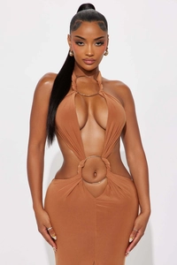 Vue détaillée de l'anneau métallique doré sur une robe moulante ajourée couleur caramel