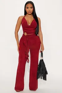 Detail of red halter top with V-neck pleats, metal ring belt and wide leg trousers