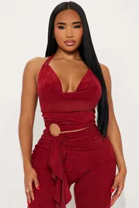 Detail of burgundy halter jumpsuit with waist cutout and metallic ring buckle decoration