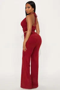 Detail of burgundy halter top and trousers set showing suede texture and tailoring