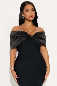 Detail of the oversized black satin bow on the elegant off-shoulder bodycon midi dress
