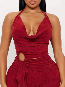 Deep red halter neck wide leg jumpsuit with waist cutouts and metal ring details