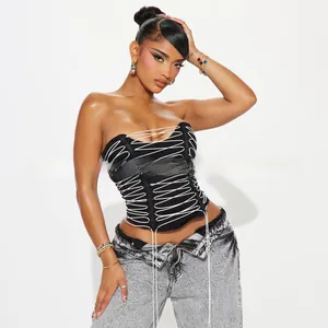 Détail d'un haut corset noir à lacets avec cordons blancs et structure baleinée sexy