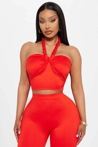 Detail of the twisted halter neckline and ruched bodice on a red two-piece fashion set