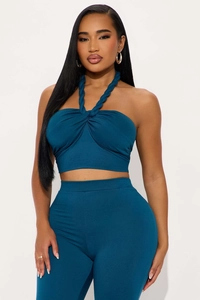 Detail of teal blue halter crop top with twisted knot front and woven strap texture