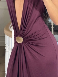 Close-up of deep V-neck dress with golden waist ring detail and pleated texture