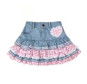 Dettaglio gonna di jeans per bambina con pizzo, fiocchi rosa e balze a quadri colorati