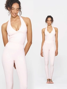 Detalle del conjunto de yoga de 3 piezas con top cruzado y leggings de cintura alta rosa