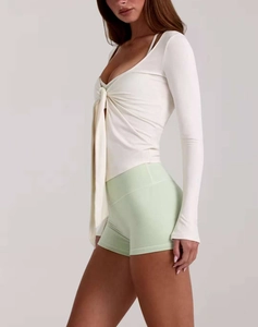 Détail du cardigan de yoga crème avec nœud de serrage à la poitrine et col en V ajusté