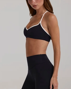 Détail d'un ensemble de yoga noir avec brassière col en V et bordure contrastée