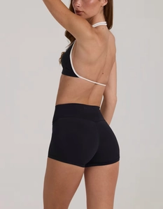 Dettaglio del top yoga con schiena scoperta e pantaloncini a vita alta Bo+Tee