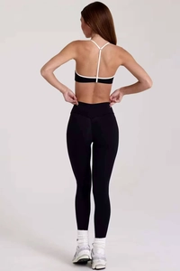 Vue arrière de l'ensemble de yoga noir et blanc avec brassière licou et legging taille haute