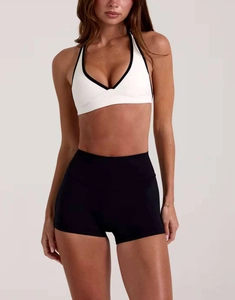 Dettaglio frontale del reggiseno sportivo bianco e pantaloncini neri a vita alta
