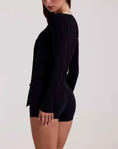 Ensemble de yoga noir ajusté avec haut à manches longues et short vu de profil arrière