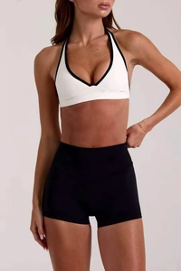 Dettaglio del reggiseno yoga bianco con bordo nero e pantaloncini a vita alta
