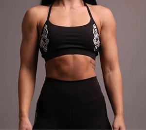 Detail of black halter sports bra and high-waisted leggings with white tiger prints