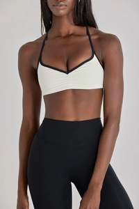 Détail de la brassière de sport avec passepoil contrasté et leggings taille haute sur modèle