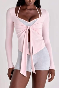 Détail du cardigan de yoga rose à nouer et de l'ensemble brassière de sport grise