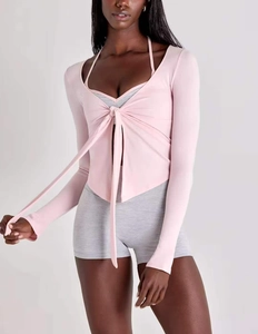 Détail d'un cardigan de yoga rose avec design à nouer et tissu à séchage rapide