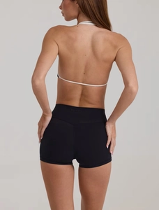 Dettaglio degli shorts sportivi neri a vita alta con logo sulla fascia posteriore, aderenti