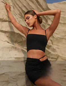 Detail of black yoga set featuring drawstring ruched skirt with waist cut-out design
