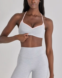 Détail d'un soutien-gorge de yoga gris chiné avec bordure rose et legging taille haute assorti