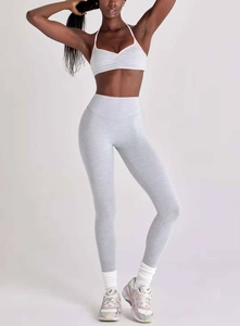 Détail du legging de yoga taille haute et soutien-gorge de sport gris bordé d'orange