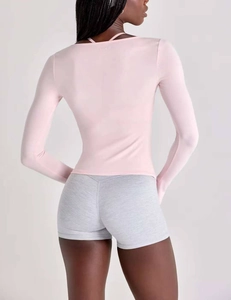 Détail du haut de yoga rose à manches longues avec bretelles croisées au dos