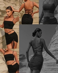 Detail of black yoga crop top with strappy back and ruched skirt with drawstring ties