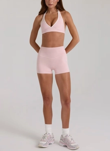 Dettaglio del set yoga rosa senza cuciture con reggiseno allacciato al collo e bordi bianchi