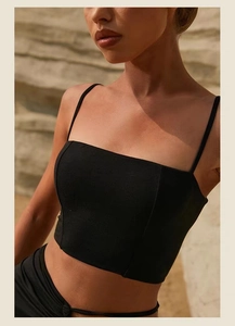 Close-up of black square-neck yoga crop top with thin straps and matte textured fabric