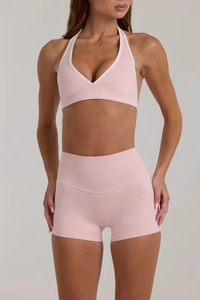 Dettaglio del set yoga rosa con pantaloncini a vita alta e reggiseno sportivo
