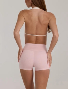 Dettaglio degli shorts da yoga rosa a vita alta con cucitura a V sul retro del modello