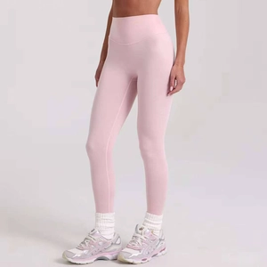 Detail of high-waisted light pink yoga pants with wide tummy control waistband