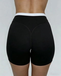Detail der schwarzen High-Waist-Sportshorts mit weißem Kontrastbund und Herzform-Naht am Gesäß