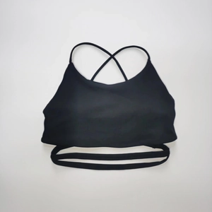 Dettaglio del reggiseno sportivo nero con spalline incrociate e fascia elastica traforata